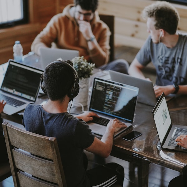 Team collaborating around a laptop